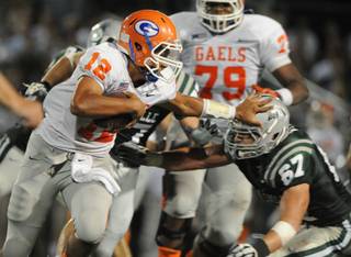 De La Salle's Dylan Wynn (67) gets pushed back by Bishop Gorman quarterback Anu Solomon (12) in the second quarter of Saturday's game in Concord, Calif.