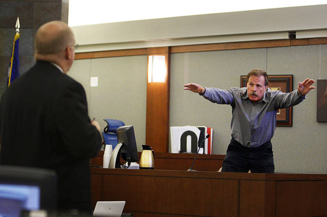 Costco employee Ralph Smithwick demonstrates how Erik Scott reacted after being shot as he testifies during a coroner's inquest for Erik Scott at the Regional Justice Center Monday, September 27, 2010. Chief Deputy District Attorney Christopher Laurent listens at left. 