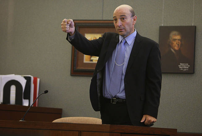 Ronald Montgomery, a law enforcement official with Homeland Security, demonstrates how Erik Scott brought up his holstered gun on a Metro Police officer as he testifies during a coroner's inquest for Erik Scott at the Regional Justice Center Monday, September 27, 2010.