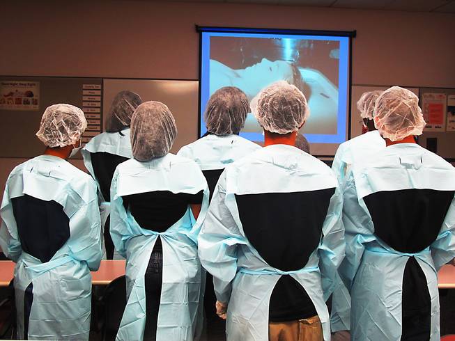 Before a behind-the-scenes tour of the coroner's office, teens look at an image of a dead Las Vegas teen. 