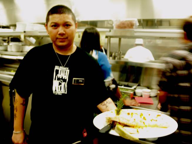 Joey, one of 100 employees hired at Hash House A Go Go's new location at the M Resort and Casino, displays a fresh cheese quesadilla ready from the kitchen. Hash House opened its third valley location at the M on Thursday.