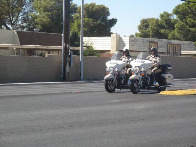 Metro police officers wait to demonstrate a safe left turn from Tropicana Avenue onto Pearl Street during a news conference Friday. A motorcyclist died Wednesday when his bike and a van collided at the intersection.