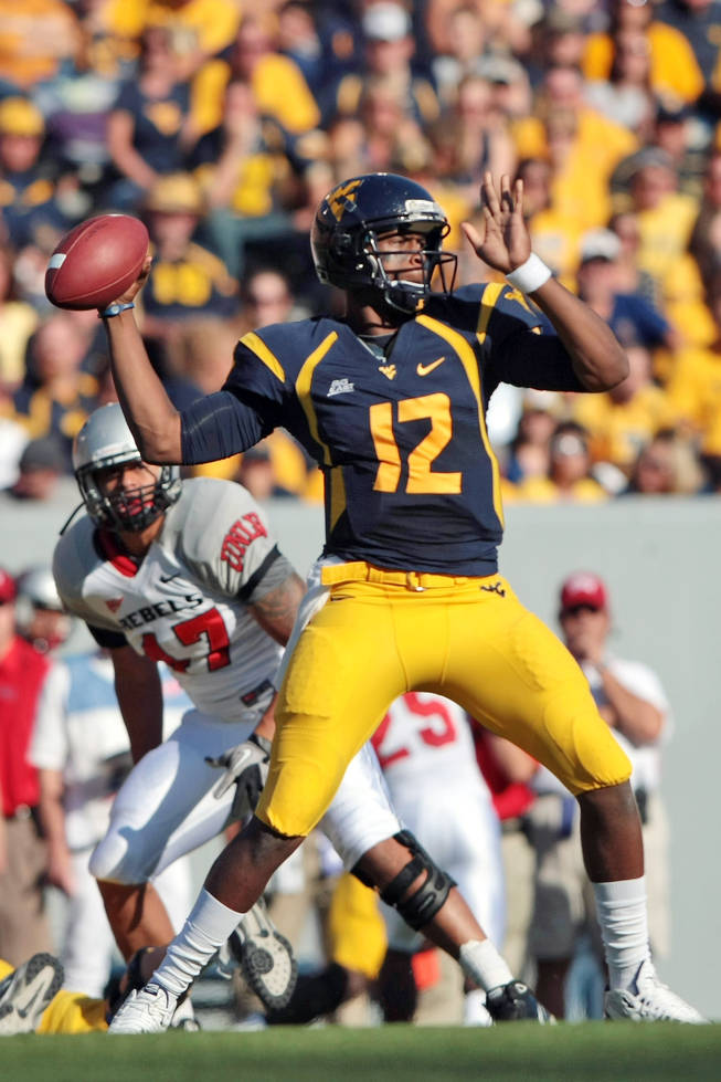 West Virginia  quarterback Geno Smith (12) drops back to pass against UNLV  in the second half of an NCAA college football game on Saturday, Oct. 9, 2010 in Morgantown, W.Va.  West Virginia defeated UNLV 49-10. 