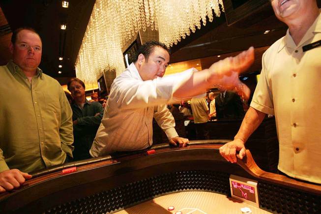 Gamblers play craps at the opening of M Resort in March 2009. In a deal announced Friday, Penn National Gaming acquired M Resort's $850 million debt for $230.5 million.