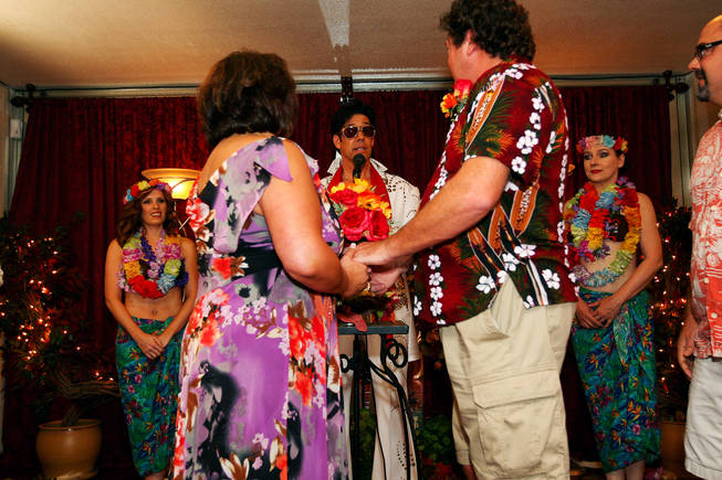 After serenading the couple, Elvis impersonator Ron DeCar pronounces Ann and David Tedone man and wife on 10/10/10 at 10 a.m. at the Viva Las Vegas Wedding Chapel.  DeCar is the owner of Viva Las Vegas Wedding Chapel.