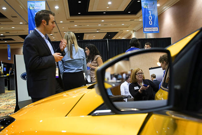 A Ford representative is reflected in the mirror of a 2011 Ford Focus during the BlogWorld & New Media Expo at the Mandalay Bay Thursday, October 15, 2010. Ford was exhibiting the MyFord Touch, a car computer system that controls navigation, phone and climate controls, enables WiFi and opens cars up to third-party apps. MyFord Touch runs on the second generation of Microsoft's SYNC system.