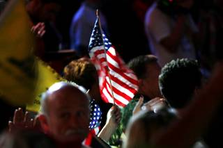 A U.S. flag is waved during a Tea Party Express rally Tuesday at Stoney's Rockin' Country bar.