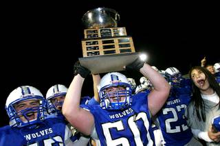 Basic's Matt Wadley is joined by teammates while showing off the Henderson Bowl trophy after defeating Green Valley during the annual Henderson Bowl game Thursday, October 28, 2010. Basic won the game for the third time in a row 32-31.