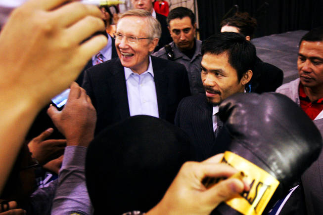 Sen. Harry Reid and boxer Manny Pacquiao sign autographs Friday at Orr Middle School in Las Vegas on Oct. 29, 2010.