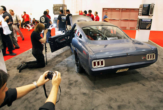 Photographer take photos of a 1965 Ford Mustang customized by the Ring Brothers at the Flowmaster muffler booth during the annual Specialty Equipment Market Association (SEMA) trade show at the Las Vegas Convention Center Wednesday, November 3, 2010.