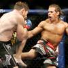 Urijah Faber, right, kicks Mike Brown during the second round of a World Extreme Cagefighting featherweight title mixed martial arts fight in Sacramento, Calif.