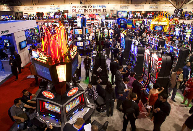 Attendees look over slot machines at the Bally booth during the Global Gaming Expo (G2E) at the Las Vegas Convention Center Tuesday, November 16, 2010.