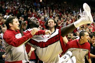 UNLV players, from left, Todd Hanni, Brice Massamba, Carlos Lopez and Karam Mashour celebrate as Justin Hawkins makes a free throw to cement their win over Wisconsin on Saturday. UNLV beat the 25th-ranked Wisconsin 68-65.