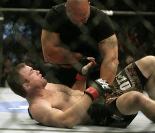 Matt Hughes, bottom, looks up at the referee after his bout was stopped 21 seconds into the first round during a welterweight mixed martial arts match against BJ Penn at UFC 123 on Saturday in Auburn Hills, Mich. Penn was declared the winner.