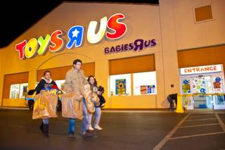 Shoppers leave with bags of toys and games after braving the cold for as long as 3 hours while waiting in line outside Toys R Us on Thursday, Nov. 25, 2010.