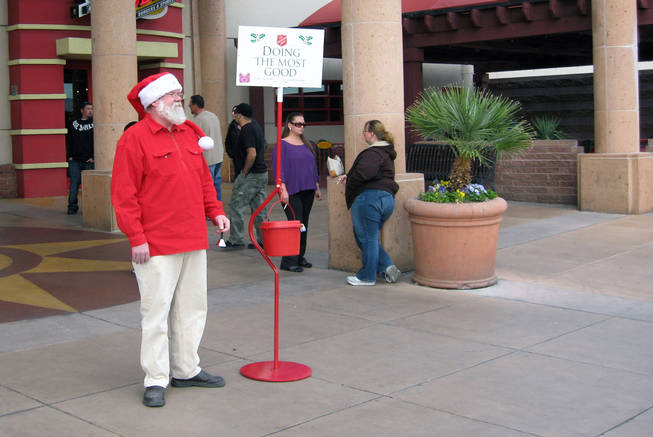 Volunteer Mark Harmon rings a bell to get donations for a Salvation Army red kettle Saturday outside an entrance to the Galleria at Sunset mall in Henderson.