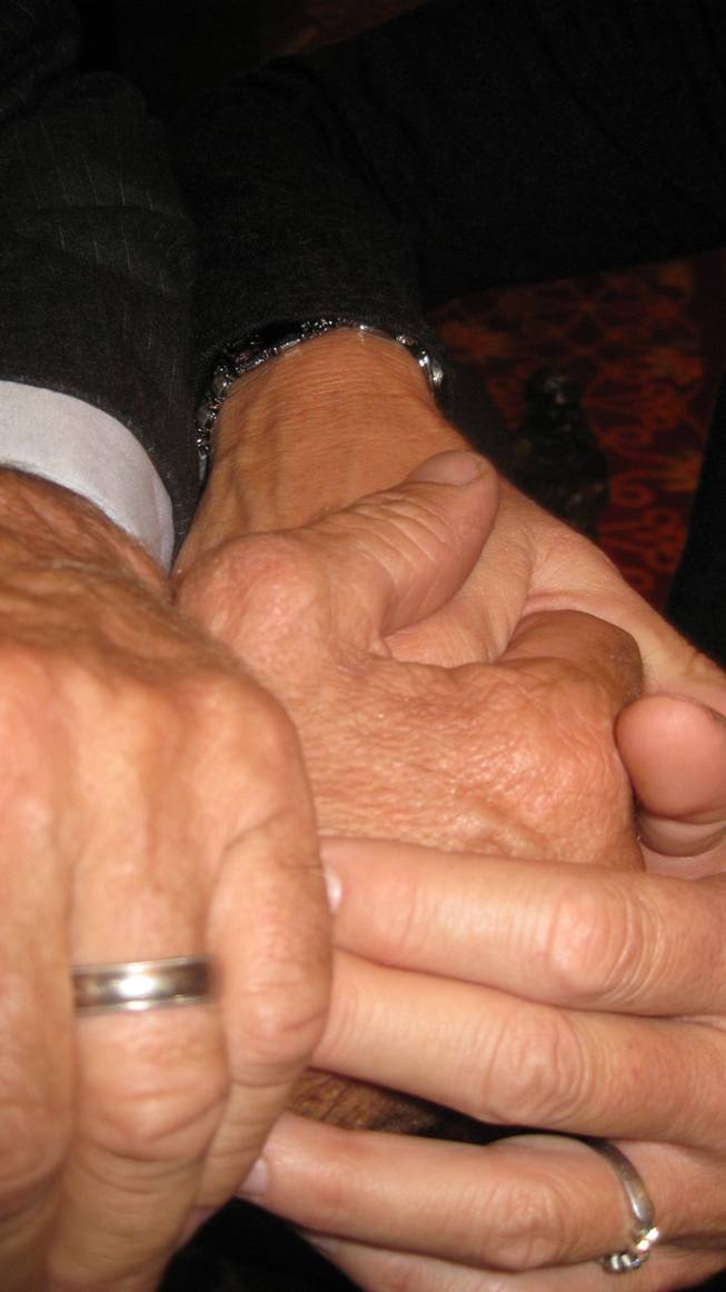 Larry Mahan's hands, showing the thumb that has weathered more than 1,200 rodeos, with those of his wife, Julanne.