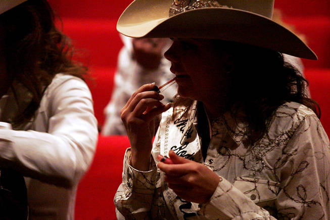 Miss Rodeo Arizona Kasey Jo Painter applies lip gloss while taking a break in rehearsal for the Miss Rodeo America Pageant on Wednesday, Dec. 1, 2010.