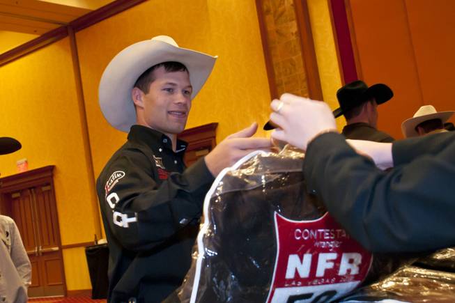 Competitor Heith DeMoss receives a National Finals Rodeo jacket, among ...
