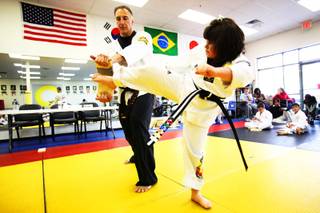 Sonya Dilks breaks a board held by instructor Dan DeNuccio at the DoJang World Training Center in Henderson on Saturday, Dec. 4, 2010. Sonya, who is autistic, recently earned her black belt in taekwondo. She is 8 years old.

