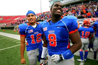 Bishop Gorman quarterback Anu Solomon (L) and defensive end Jalen Grimble smile as they watch the final seconds tick away during their state championship football game against McQueen Saturday, December 4, 2010 at Sam Boyd Stadium. Gorman won 40-0 for back-to-back championships and their third in four years.