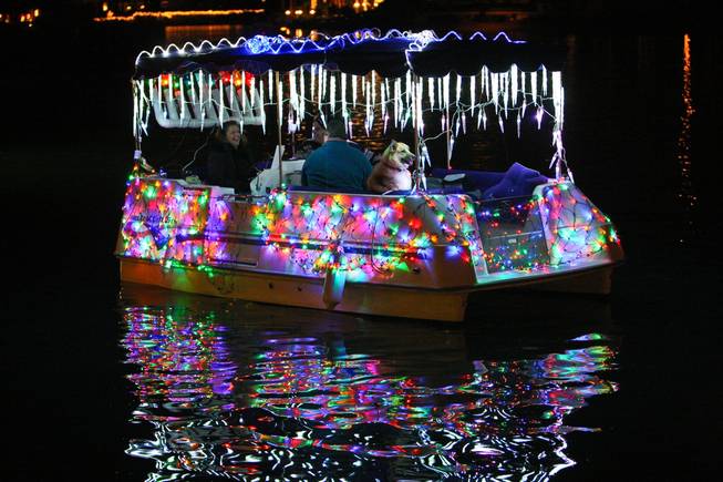 Boats donning sparkling lights participate in the the annual Festival of Lights on Saturday at The Lakes.