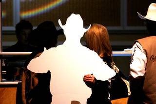 A rodeo fan carries a cardboard cutout of a PRCA cowboy up to the bar at the NFR World Champion Awards Show and After Party at the Mirage Saturday, December 11, 2010.