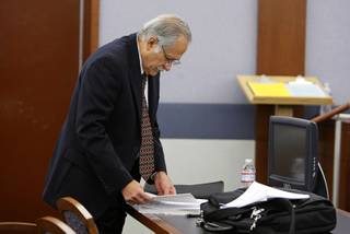 Edward Preciado-Nuno looks over paperwork during a break in his murder trial at the Regional Justice Center Thursday, December 16, 2010. Preciado-Nuno, a retired FBI special agent, is accused of killing his son's girlfriend Kimberly Long. Preciado-Nuno says he was attacked by the girlfriend and killed her in self-defense.