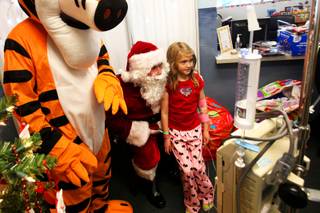 Maddy Tanner, 8, gets her photo taken with Santa Claus and Tigger on Friday, Dec. 17, 2010, at the Comprehensive Cancer Centers of Nevada in Las Vegas, where she is a patient. The holiday event was organized by Pro-Tect Security, which has been providing photo opportunities with Santa and gifts to hospital children for the past decade.