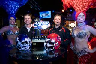 Boise State coach Chris Petersen, left, and Utah coach Kyle Whittingham pose with showgirls during a news conference at the Hard Rock Cafe on the Las Vegas Strip Sunday, December 19, 2010. Utah is scheduled to face Boise State in the MAACO Bowl Las Vegas NCAA college football game at Sam Boyd Stadium on Wednesday.