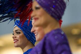 Showgirl Porsha Revesz, left, listens to speakers during the unveiling of a 627-square-foot video wall in the D Concourse rotunda of McCarran International Airport Monday, Jan. 3, 2011. 