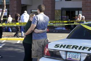 Two people embrace each other at the scene where Rep. Gabrielle Giffords, D-Ariz., and others were shot outside a Safeway grocery store in Tucson, Ariz. on Saturday, Jan. 8, 2011.