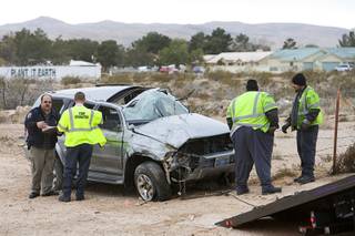 Tow operators prepare to load an SUV after a fatal crash on I-15 southbound near Blue Diamond Road on Tuesday, Jan. 11, 2011. A female passenger in the SUV was ejected and killed.