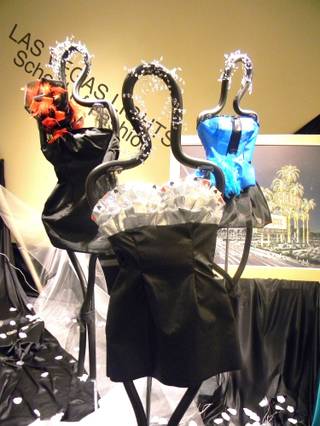Three of the dresses, displayed here at the Centennial Hills Library, designed by junior fashion students at Southwest Career and Technical Academy for their winter showcase. Their work will be featured at the library until the end of January.