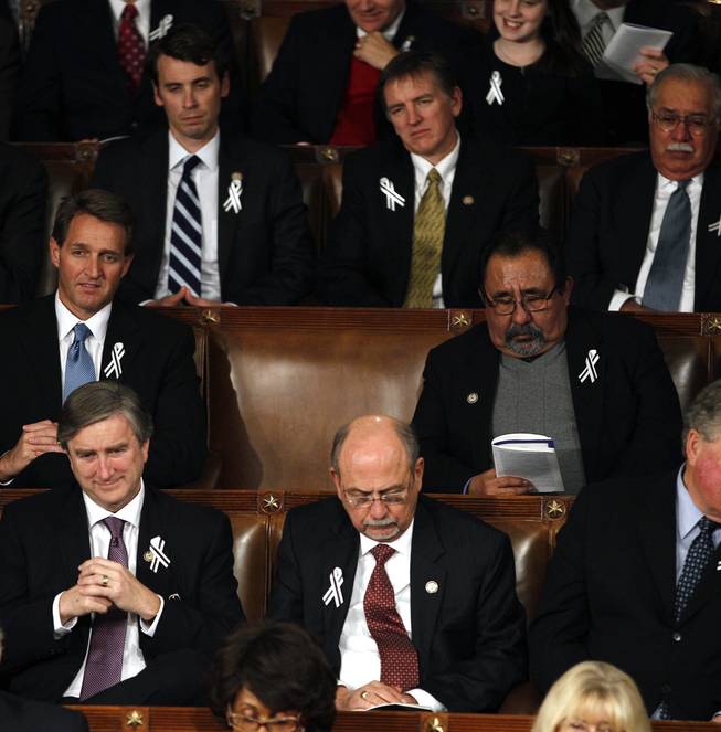 An empty seat for Rep. Gabrielle Giffords, D-Ariz. is seen on Capitol Hill in Washington, Tuesday, Jan. 25, 2011, during President Barack Obama's State of the Union address. Rep. Jeff Flake, R-Ariz. is at left, Rep. Raul Grijalva, D-Ariz. is at right.
