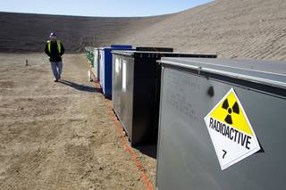 A worker walks by containers of mixed waste in the Area 5 Radioactive Waste Management Site of the Nevada National Security Site (N2S2), previously the Nevada Test Site, about 65 miles northwest of Las Vegas on Feb. 1, 2011. 