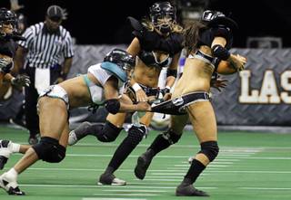 Marirose Roach, left, of the Philadelphia Passion puts the pressure on quarterback Ashley Salerno of the Los Angeles Temptation during the Lingerie Bowl VIII at the Thomas & Mack Center Sunday, Feb. 6, 2011. The event was a pay-per-view show that could be ordered at half-time of Super Bowl XLV. The Las Vegas Sin, an expansion team, will join the Lingerie Football League this fall.