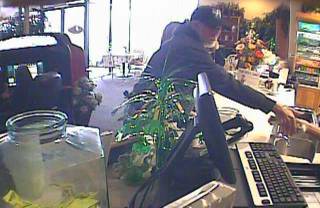 A photo from a surveillance camera shows a man allegedly robbing a business Saturday in the 5000 block of Charleston Boulevard.
