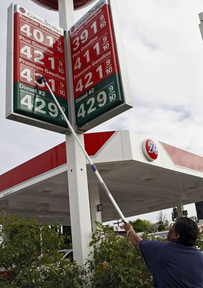 In this March 2, 2011, file photo, a gas station attendant raises gas prices on a sign at a station in the Hollywood section of Los Angeles.  Gasoline prices have shot up by an average of 35 cents per gallon since an uprising in Libya began in mid-February. A gallon of regular unleaded gained another 4.4 cents overnight to a new national average of $3.471 per gallon, according to auto club AAA, Wright Express and the Oil Price Information Service.