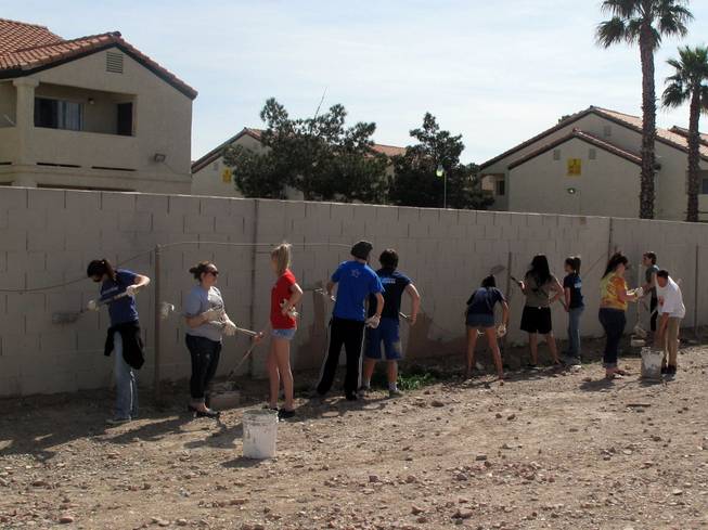 Students from the youth program at the Crossing Christian Church paint over graffiti Saturday near U.S. 95 and Charleston Boulevard.