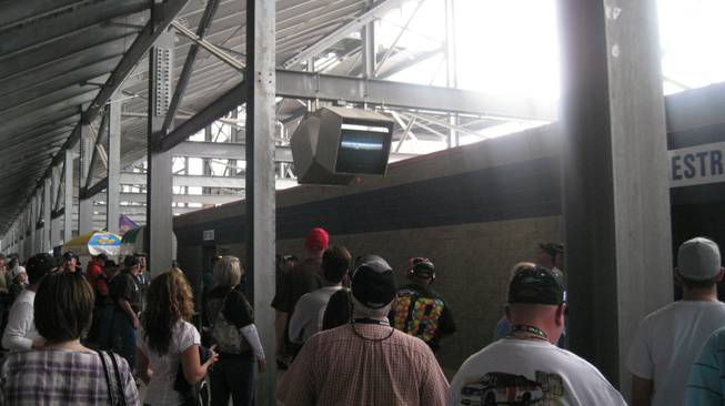 Fans in the concourse catch up on the action on one of the Speedway monitors before returning to their seats.