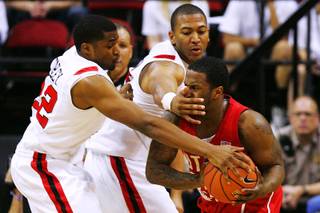 Utah guard Josh Watkins gets slapped in the face while being defended by San Diego State's Chase Tapley (L) and Tim Shelton during their Mountain West Conference Championship game Thursday, March 10, 2011 at the Thomas & Mack Center. San Diego State won 64-50.