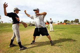 Todd Faranda, baseball coach at Chaparral High School, gives instructions to pitcher Rustin Ostrow, a sophomore, at the Chaparral baseball field Wednesday, March 16, 2011. 