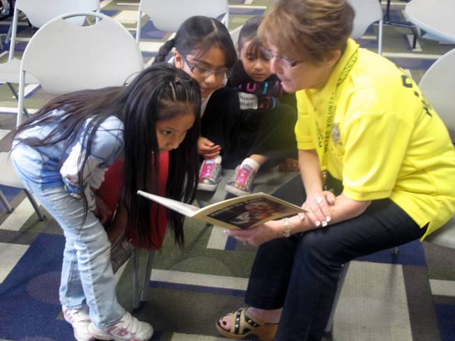 A Metro Police volunteer reads to children whose parents are attending the Hispanic Citizens Academy at the Pearson Community Center. Childcare is provided during the academy, which provides police an opportunity to foster good relationships with Hispanic children.