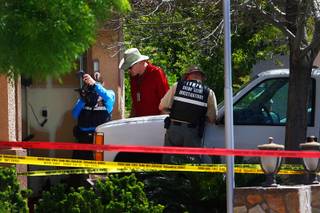 Metro detectives and crime scene investigators probe an officer-involved shooting Tuesday, April 12, 2011. A Metro officer shot and killed a suicidal man who pointed a gun at police while in his garage.