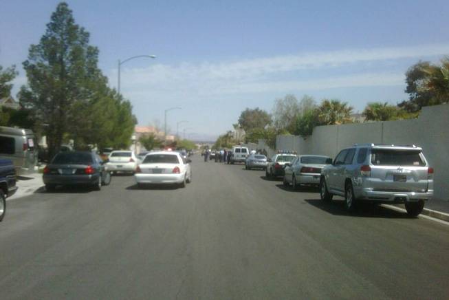In this cellphone photo, Metro Police investigate an officer-involved shooting Tuesday, April 12, 2011, near Grand Canyon Drive and Alexander Road in the northwest valley. 