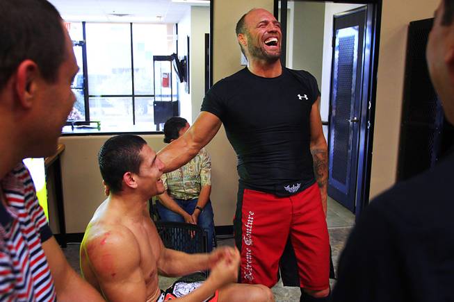 Randy Couture laughs with sparring partner Cezar Ferreira after a workout with him Thursday, April 21, 2011. 