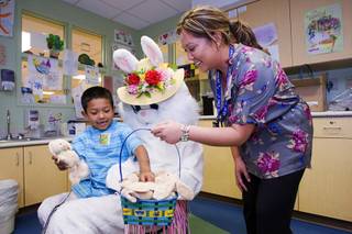 Edgar Garcia, 5, visits with the Easter bunny at Sunrise Children's Hospital Sunday, April 24, 2011. Kimberly Au-Yeung, a childlife specialist, is at right. Garcia was visiting his brother, who is a patient in the hospital. The visit was courtesy of E-BUNNY, a volunteer organization that provides Easter baskets to disadvantaged children in the Las Vegas Valley.