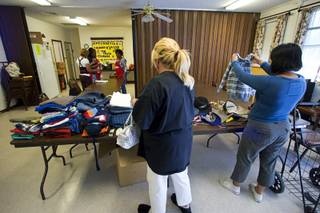 Recipients of the Fish Inc. program look over donated clothing at the Calvary Southern Baptist Church in North Las Vegas Wednesday, April 27, 2011. The program provides emergency food assistance to people who are struggling to get by.