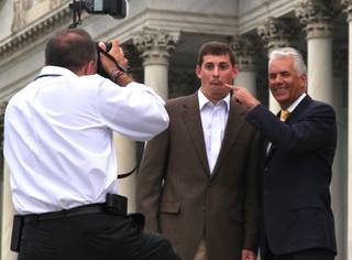 Sen. John Ensign has some fun with a staff member while taking office photographs on the steps of the Senate at the Capitol in Washington, D.C., on Thursday, April 28, 2011.